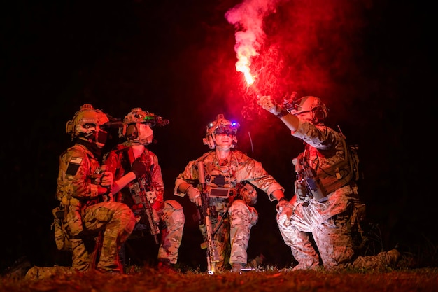 Soldiers in camouflage uniforms aiming with their rifles during Military Operation at night soldiers