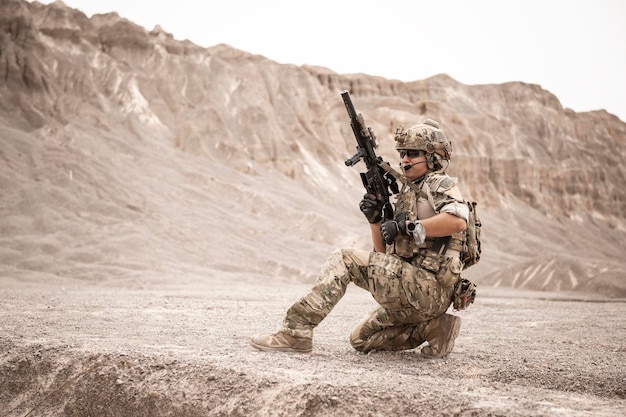 Photo soldiers in camouflage uniforms aiming with their rifles ready to fire during military operation