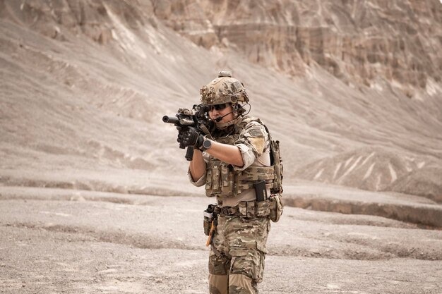 Photo soldiers in camouflage uniforms aiming with their rifles ready to fire during military operation