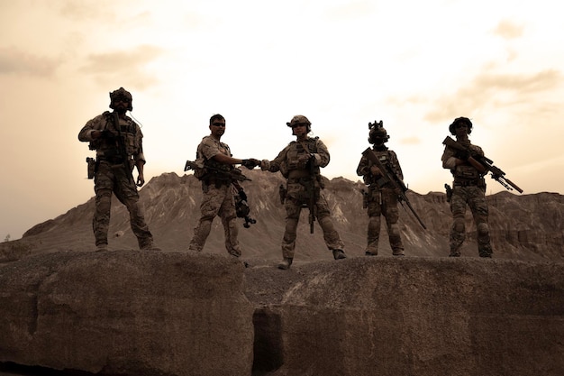 Photo soldiers in camouflage uniforms aiming with their rifles