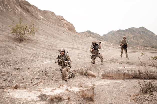 Photo soldiers in camouflage uniforms aiming with their rifles