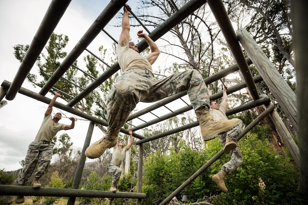 Soldiers climbing monkey bars