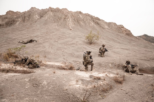 写真 カモフラージュのユニフォームを着た兵士がライフルを狙っている