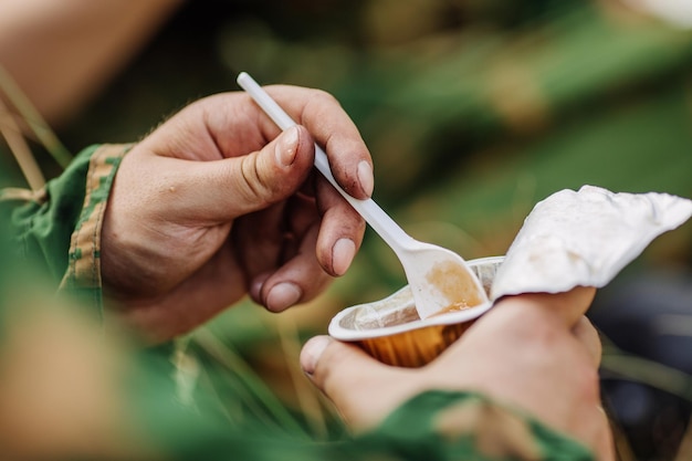 Soldiers team are heated food on the fire and eat in the forest