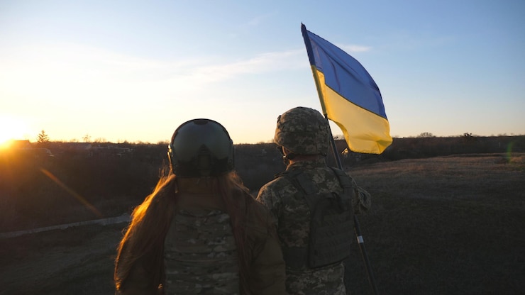 Фотография солдаты украинской армии поднимают флаг украины на фоне заката люди в военной форме подняли желто-голубой флаг победа над российской агрессией концепция сопротивления вторжению