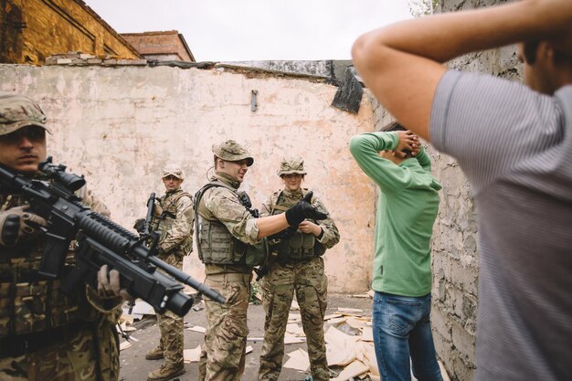 武器を持った兵士が人々を捕らえた