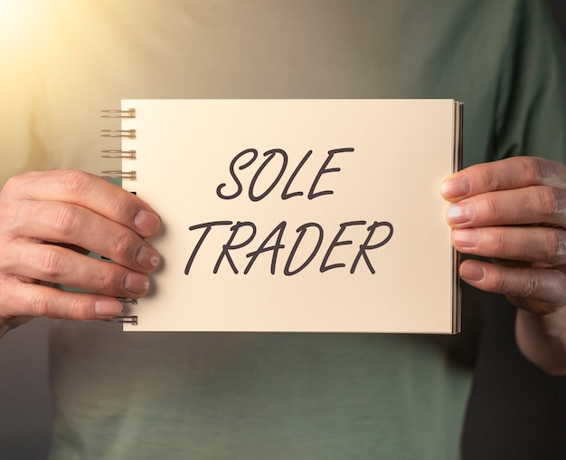 Sole trader text on note in hand of man