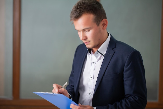 Solid businessman in a jacket works with documents in the office of the company.