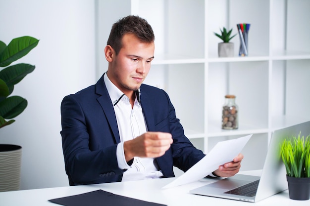Solid businessman in a jacket works with documents in office of the company