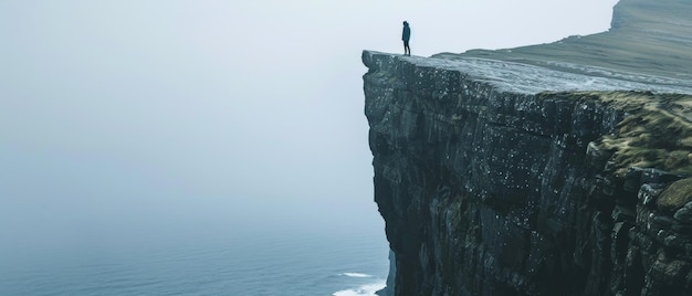 Photo solitary figure stands at the edge of a majestic cliff