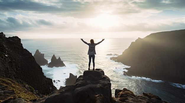 A solitary person standing on a cliff arms outstretched and facing the ocean representing a sense of