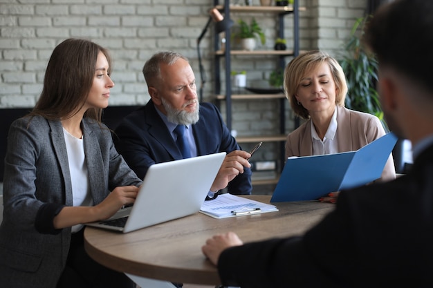 Sollicitatiegesprek met de werkgever, business team luistert naar de antwoorden van de kandidaat.