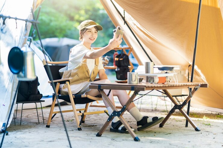 Photo ソロキャンプ画像-スマートフォンで自分撮りをしている女性