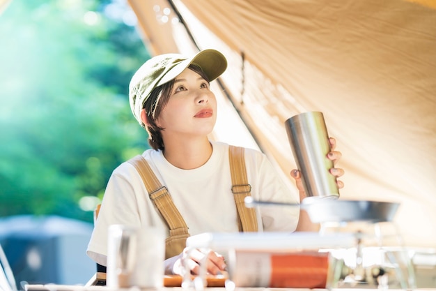 ソロキャンプ画像-アルコールを飲む若い女性