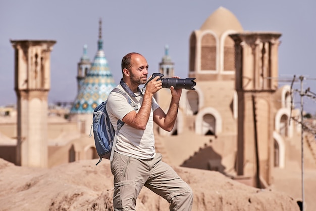 Solo traveler makes photo in old city during independent individual travel, Kashan, Iran.