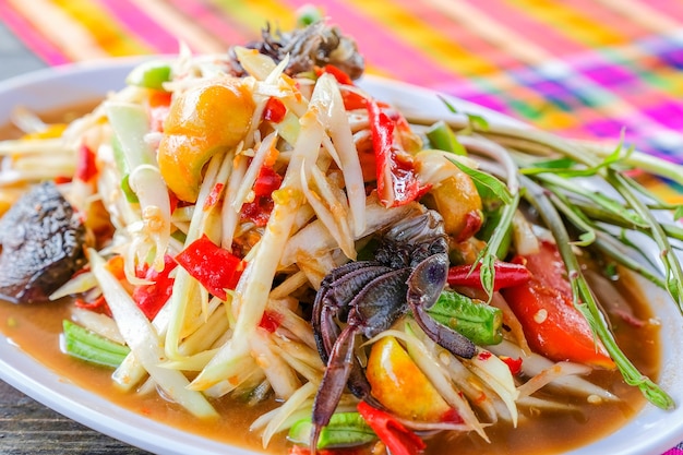 Som tam (insalata di papaya piccante) con granchio salato, sul tavolo di legno (cibo tailandese)