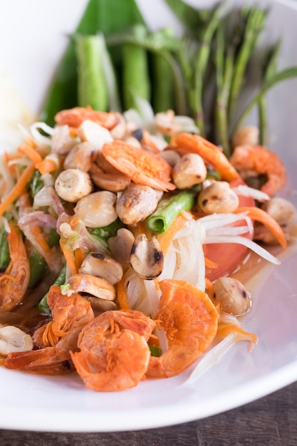 Som tum or thai spicy salad on white dish