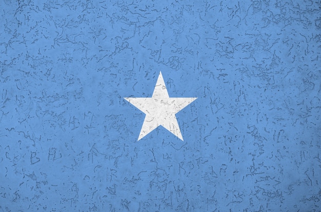 Photo somalia flag depicted in bright paint colors on old relief plastering wall.