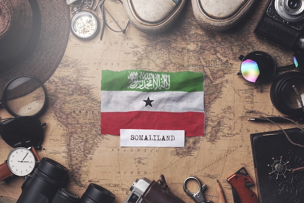 Somaliland Flag Between Traveler's Accessories on Old Vintage Map. Overhead Shot