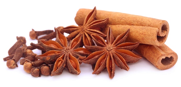 Some aromatic cinnamon with star anise and cloves over white background