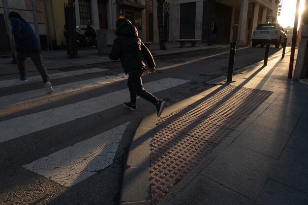 写真 背景に車がある歩行者横断路を横断する子供たち