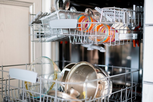 The some dirty dish tableware on the tray in dishwasher machine in the kithcen