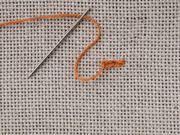 Some embroidery stitches on the canvas with a needle