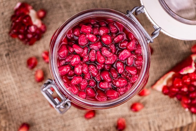 Some fresh preserved Pomegranate seeds on wooden background selective focus closeup shot
