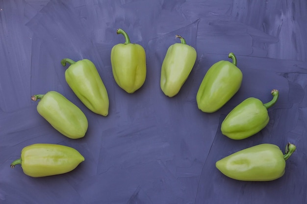 Some green bell peppers on grey background