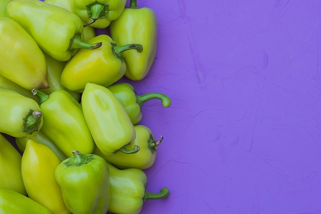 Some green bell peppers on lilac background