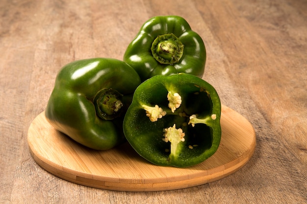 Some green peppers over a wooden surface. Fresh vegetable.