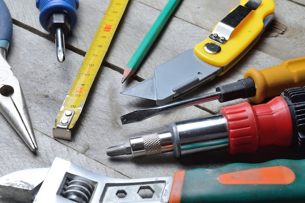 Some home repair tools lie on a wooden background. close-up.