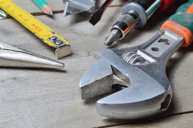 Some home repair tools lie on a wooden background. close-up.