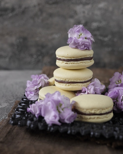 some lavender macarons on grey background, decorated with flowers. French pastries