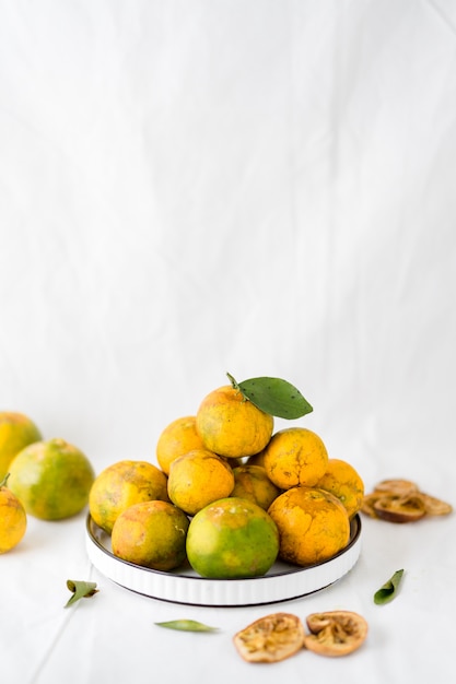 Some local oranges are piled on ceramic plates.