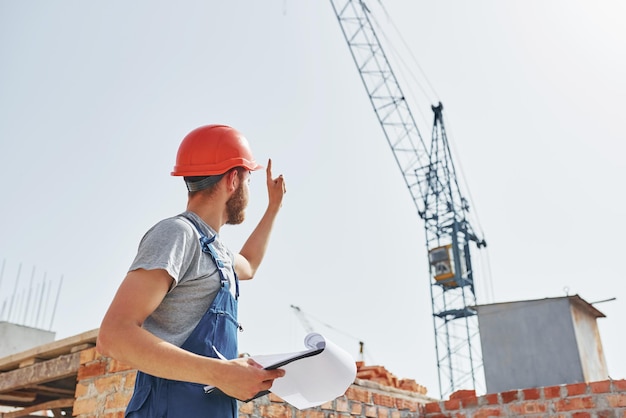 何人かの事務処理制服を着た若い建設労働者が未完成の建物で忙しい