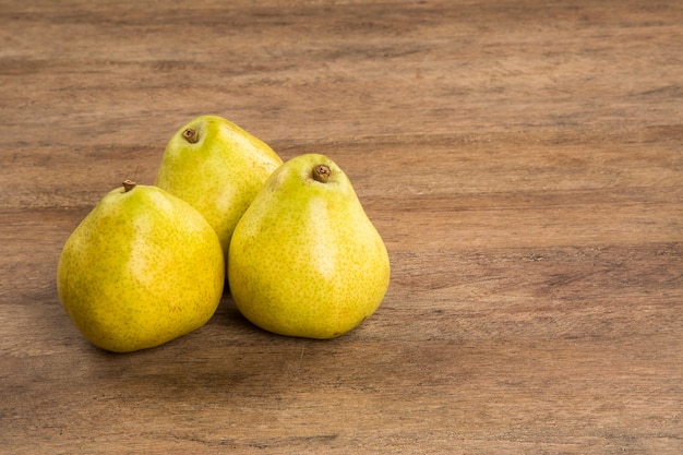 Foto alcune pere in un cesto su una superficie di legno. frutta fresca