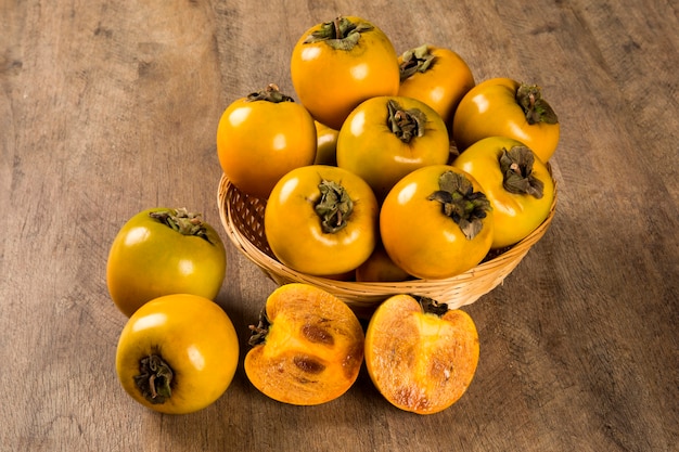 Some persimmon fruits over a wooden surface. Fresh fruit.