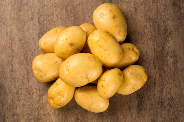 Some potatoes over a wooden surface. Fresh vegetable.