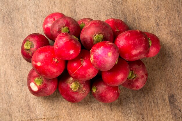 Some radishes in a basket over a wooden surface. Fresh vegetable.