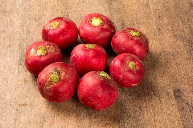 Some radishes in a basket over a wooden surface. Fresh vegetable.