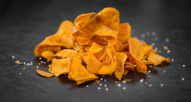 Some Sweet Potato Chips on a dark slate slab