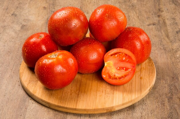 木製のテーブルの上にいくつかのトマト。新鮮な野菜。