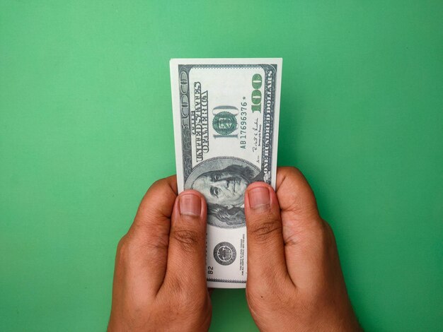 Photo someone hand holding banknotes on a green background
