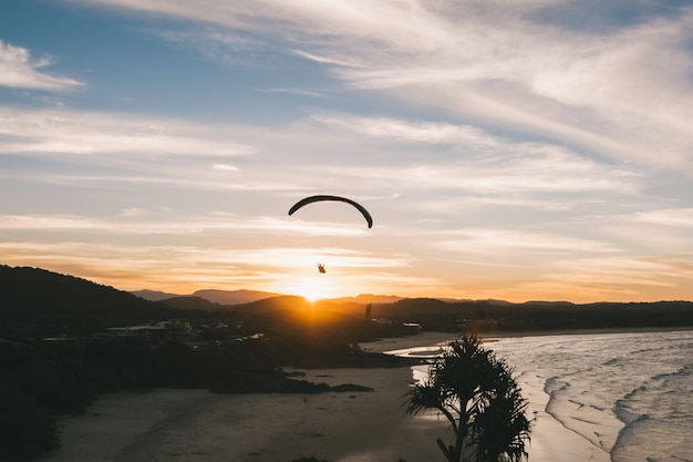 someone paragliding at sunset on the beach amazing landscape