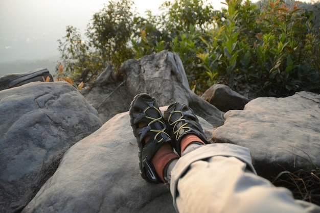 Someone shoes sit on rock for see view nature