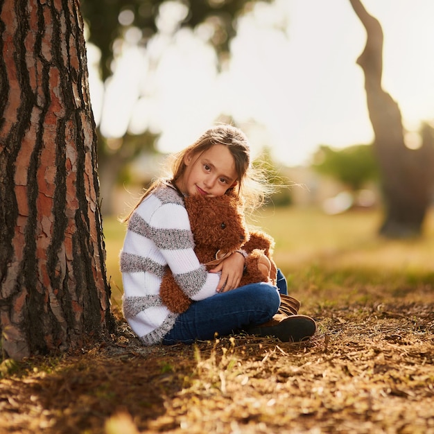 Sometimes all you need is a hug from your bear Portrait of a sweet little girl hugging her teddy bear while playing outside