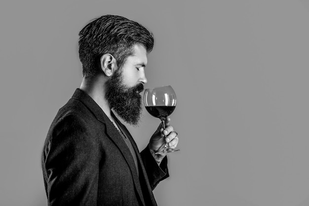 Photo sommelier degustator with glass of wine winery male winemaker man with a glass of red wine in his hands man sommelier tasting red wine black and white