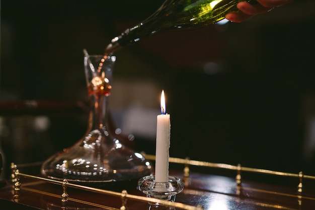 A sommelier pouring red wine into decanter