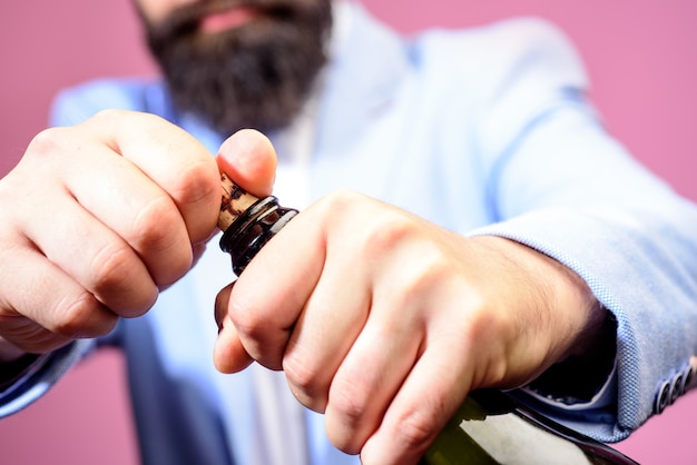 Sommelier with wine bottle selective focus bartender opening wine bottle handsome man in suit opens